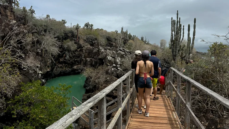Visitors on the wooden walkway beside the water-filled volcanic fissure at Las Grietas